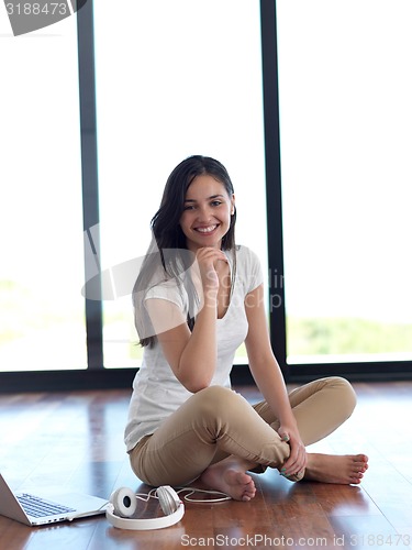 Image of relaxed young woman at home working on laptop computer