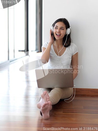 Image of relaxed young woman at home working on laptop computer