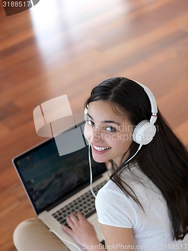 Image of relaxed young woman at home working on laptop computer