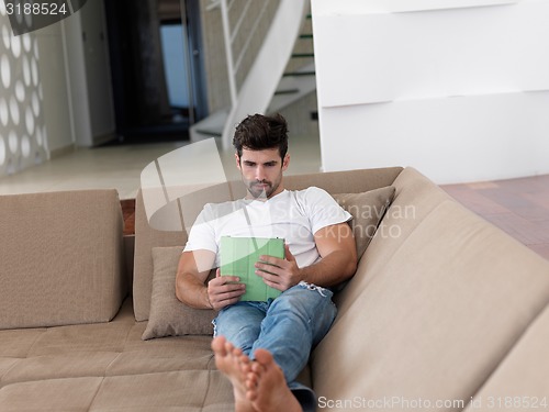 Image of man using tablet computer from home