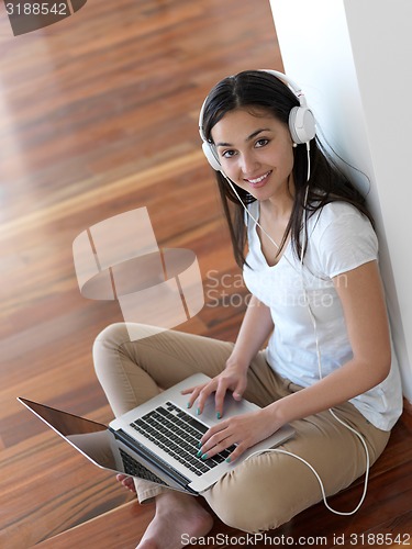 Image of relaxed young woman at home working on laptop computer