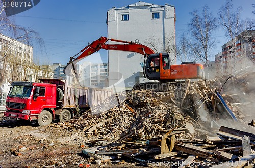 Image of Excavator loads garbage from demolished house