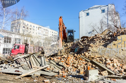 Image of Excavator loads garbage from demolished house