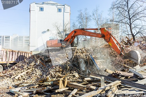 Image of Excavator loads garbage from demolished house