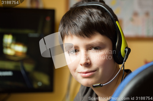 Image of Boy using computer at home, playing game