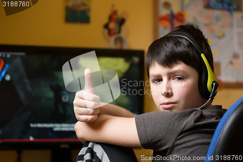 Image of Boy using computer at home, playing game