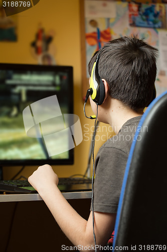 Image of Boy using computer at home, playing game