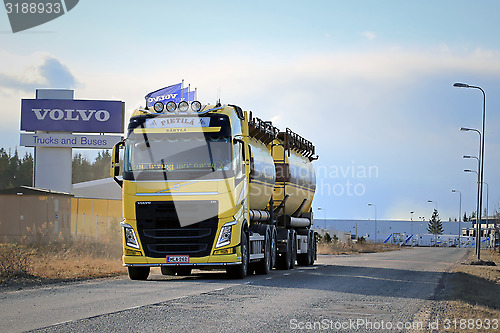 Image of Yellow Volvo FH Tank Truck on the Road with Volvo Trucks Sign