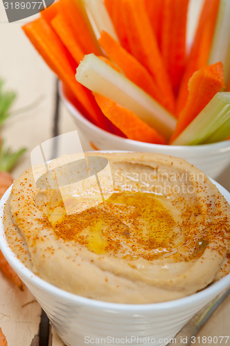 Image of fresh hummus dip with raw carrot and celery 