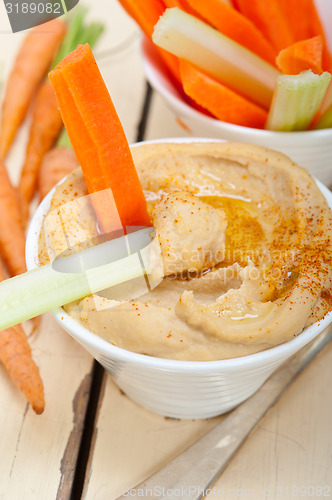 Image of fresh hummus dip with raw carrot and celery 