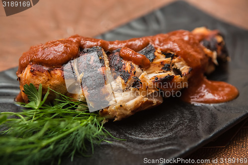 Image of the cut chicken fillet baked in spices and tomato sauce