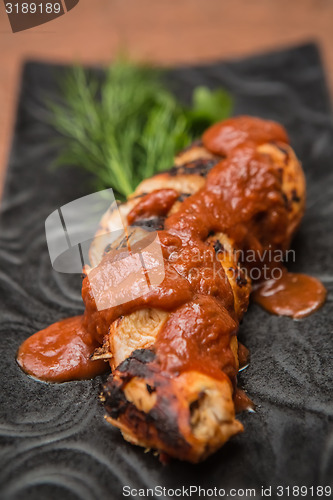 Image of the cut chicken fillet baked in spices and tomato sauce