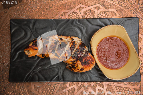 Image of the cut chicken fillet baked in spices and tomato sauce