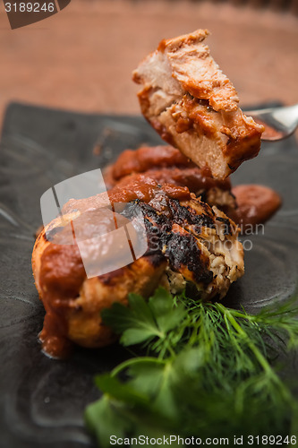 Image of the cut chicken fillet baked in spices and tomato sauce