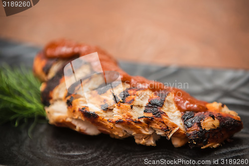 Image of the cut chicken fillet baked in spices and tomato sauce