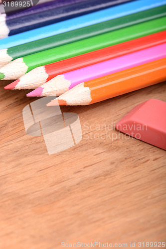 Image of pencil set on wooden plate with eraser