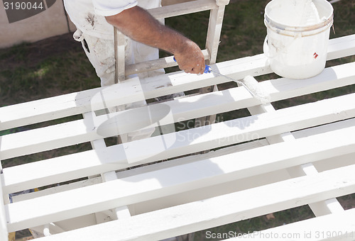 Image of Painter Rolling White Paint Onto Top of Patio Cover