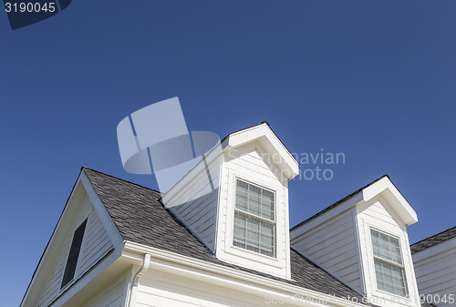 Image of Roof of House and Windows Against Deep Blue Sky