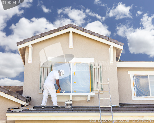 Image of House Painter Painting the Trim And Shutters of Home