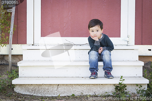 Image of Cute Mixed Race Boy Sitting on the Steps of a Barn