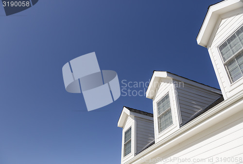 Image of Roof of House and Windows Against Deep Blue Sky