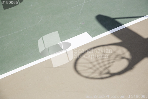 Image of Shadow of Basketball Hoop and Net Against Court