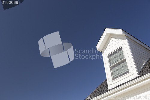 Image of Roof of House and Windows Against Deep Blue Sky