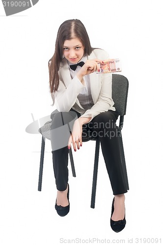 Image of Pretty businesswoman with roubles sits on chair