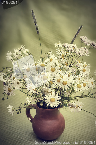 Image of Bouquet of wild flowers in a clay pot, close-up  
