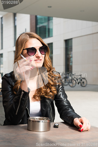 Image of Young woman smoking a cigarette 