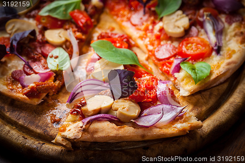 Image of Homemade pizza with dried tomatoes and salami 