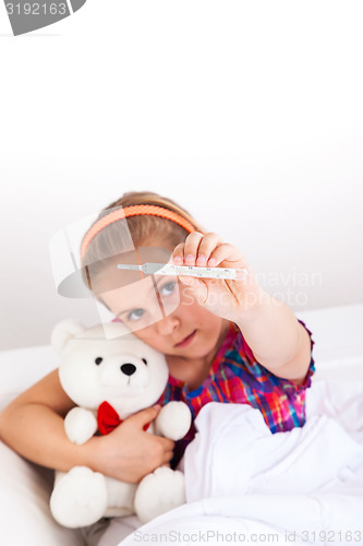 Image of Cute girl showing thermometer