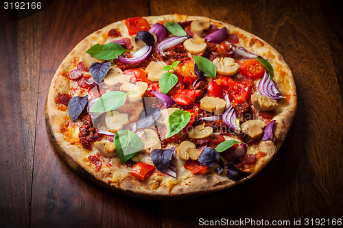 Image of Homemade pizza with dried tomatoes and salami 