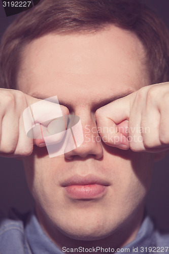 Image of man covering face with his both hands