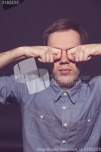 Image of man covering face with his both hands