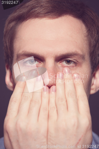 Image of Speak no evil concept - Face of men covering his mouth. 