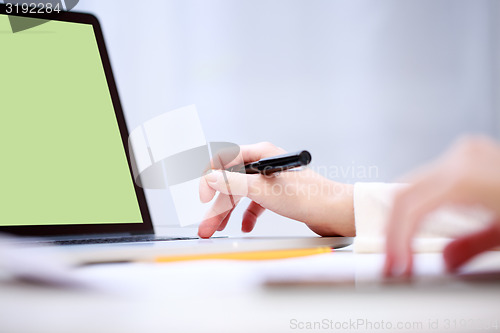 Image of Woman analyzing something at laptop.