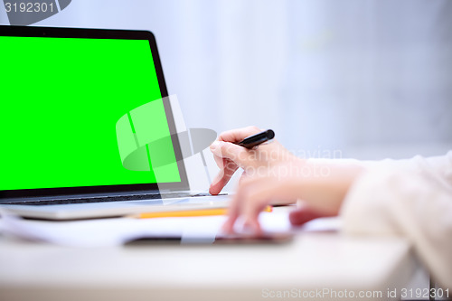 Image of Woman analyzing something at laptop.