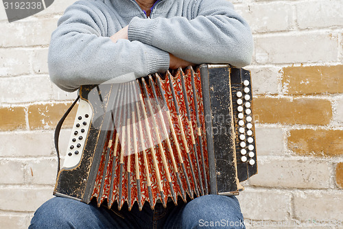 Image of  concertina on the man\'s knee
