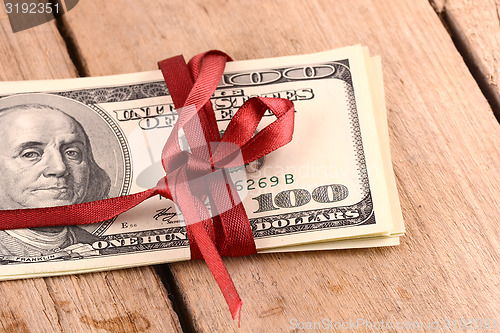 Image of Bundle of dollars tied with ribbon