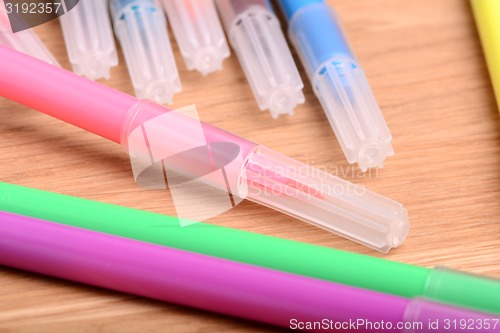 Image of highlighter markers set on wooden plate