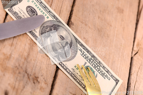 Image of american money on wooden plate with knife and fok