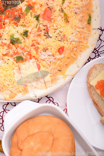 Image of Beef pizza on white plate with red pepper