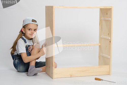 Image of Girl collects garbage furniture chest of drawers