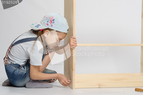 Image of Little girl in overalls collector furniture screw spins