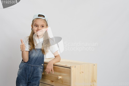 Image of Girl in overalls collector relies on the chest shows class