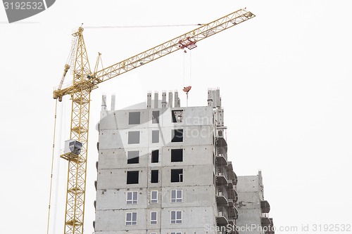 Image of Unfinished house with a crane on construction site