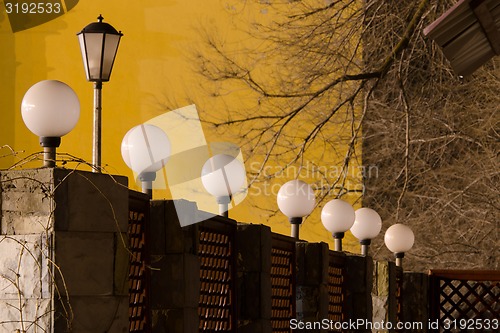 Image of number of street lights on the fence in evening