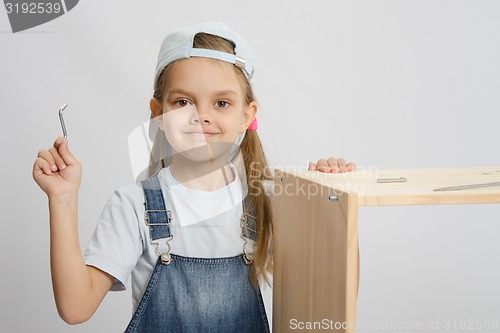 Image of Little girl in image collector of furniture with tools