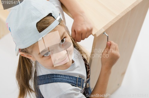 Image of Little girl in dress collector furniture tighten screws Allen